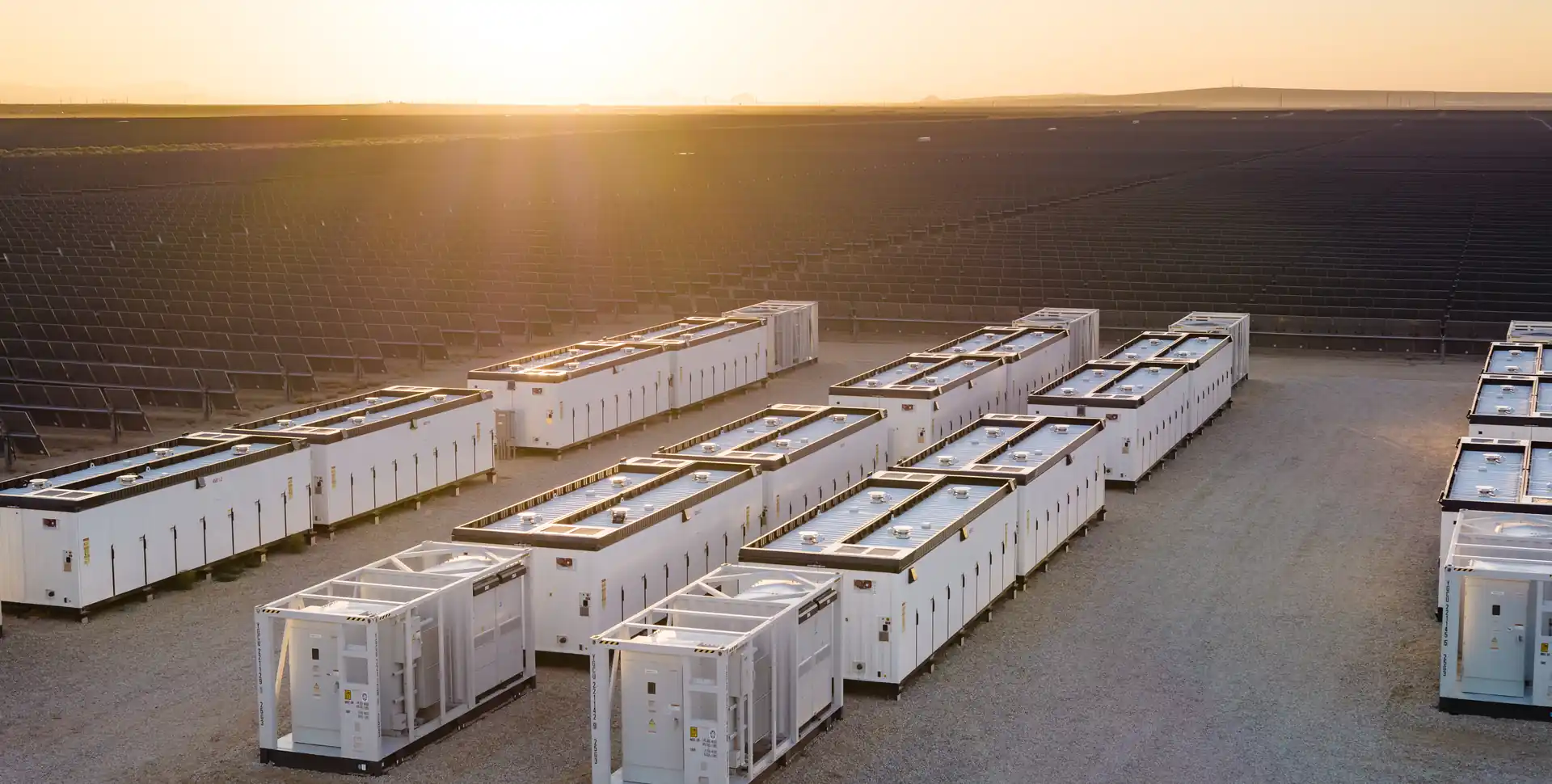 Contenedores de almacenamiento de energ&iacute;a en bater&iacute;as en una central solar al atardecer