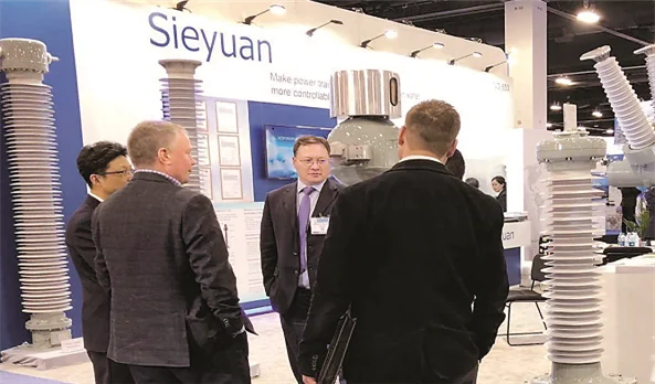 Visitantes conversan con el personal de Sieyuan en su stand de la feria IEEE PES T&D
