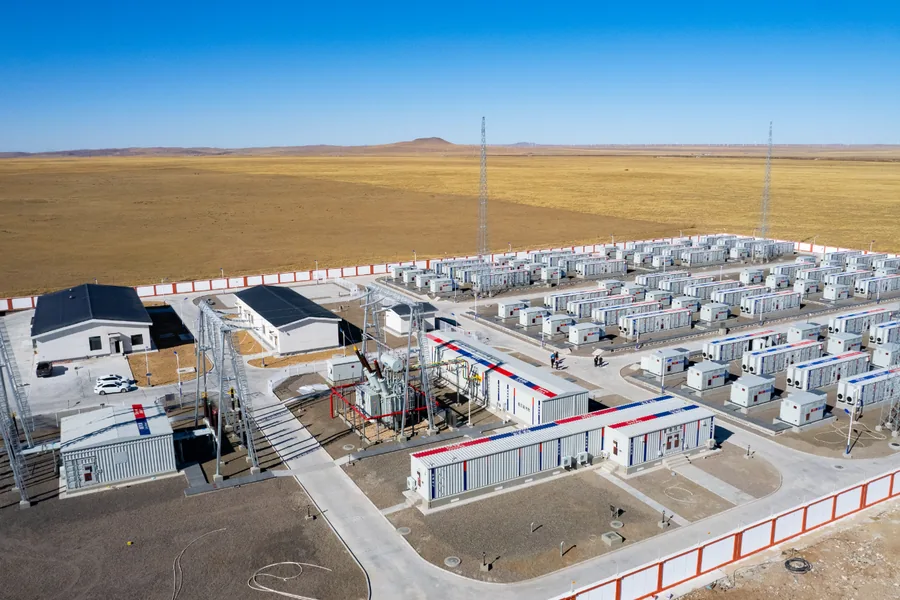 Filas de módulos prefabricados de almacenamiento en baterías y E-House en un emplazamiento renovable en una pradera