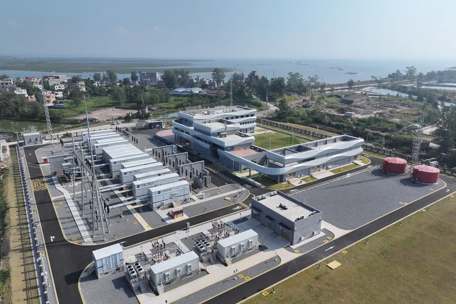 Vista aérea de una instalación industrial costera con E-House modulares junto a una subestación exterior